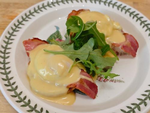 a plate of food with bacon and greens on it at Anton Guest House Bed and Breakfast in Shrewsbury