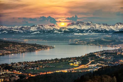 a view of a city with snow covered mountains at Top duplex Apartment Zurich-Limmattal in Killwangen