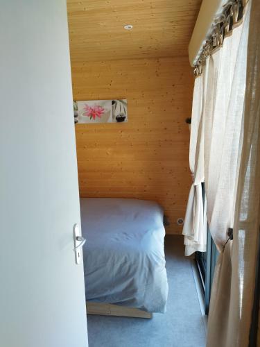 Ένα ή περισσότερα κρεβάτια σε δωμάτιο στο Le Nid en Bois