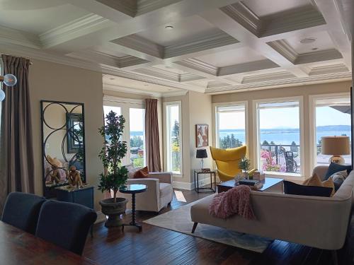 a living room with a couch and chairs and windows at Sand and Salt Bed & Breakfast in White Rock