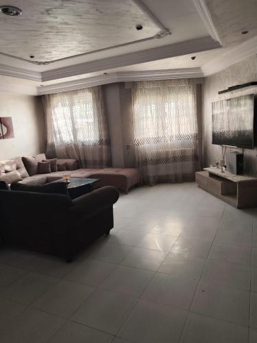 a living room with a couch and a tv at Tiba soliman plage in Nabeul