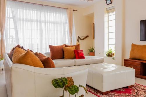a living room with a white couch and a window at Lamuria Naetoi Villa in Nanyuki