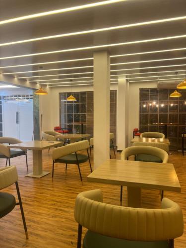 a waiting area with tables and chairs in a building at White Land City Hotel in Dambulla