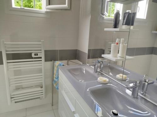 a white bathroom with a sink and a mirror at Maison de vacances à Lesperon in Lesperon