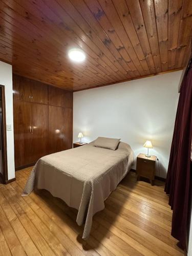 a bedroom with a bed and a wooden ceiling at La Rosa House - Central house in Eldorado in Eldorado