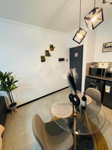 a living room with a glass table and chairs at Chanty Serenity Apartment with Pool and Gym in Sandton
