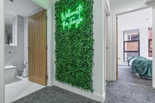 a green wall with a sign on it in a bathroom at 2 BR Luxury Central Apartment Near Colmore Row in Birmingham