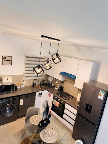 a kitchen with a refrigerator and a table with chairs at Chanty Serenity Apartment with Pool and Gym in Sandton