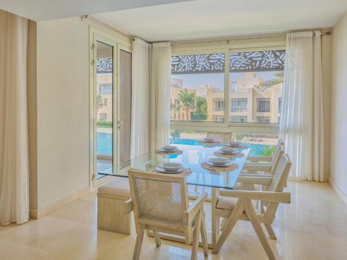 a dining room with a table and chairs and a large window at Boutique Residence Mangroovy-Lemon Spaces Gouna in Hurghada