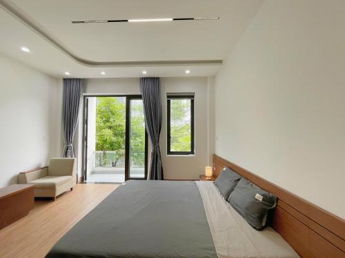 - une chambre avec un lit, un canapé et des fenêtres dans l'établissement Lona Home & Aparment, à Đà Nẵng