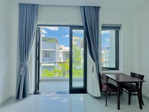 une salle à manger avec une table et une grande fenêtre dans l'établissement Lona Home & Aparment, à Đà Nẵng