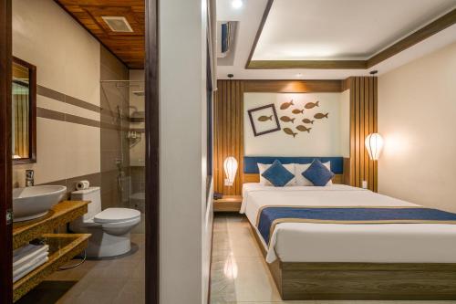a bedroom with a bed and a sink and a toilet at Southern Hotel in Hoi An