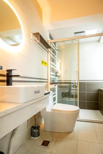 a bathroom with a toilet and a sink and a shower at The Lu Village Retreat in Guilin