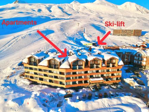 a resort in the snow with two arrows pointing to the ski lift at GVC 3-room 412 New Gudauri in Gudauri