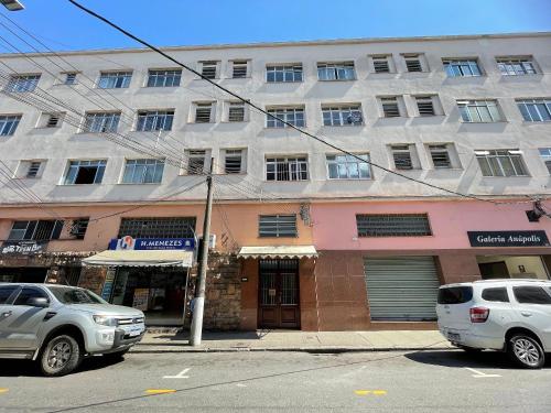 a building on a street with cars parked in front at Conforto praticidade Centro Histórico Petrópolis in Petrópolis
