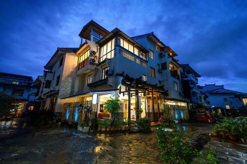 a large blue building with lights on at The Lu Village Retreat in Guilin