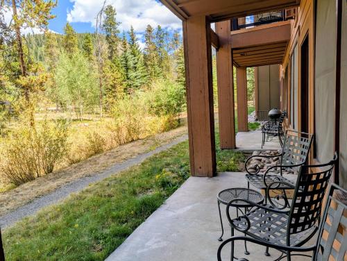 a porch with chairs and a view of the woods at Springs 8806 by SummitCove Lodging in Colorado in Keystone