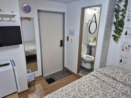 ソウルにあるSoon Guesthouseのベッド1台、バスルーム(トイレ付)が備わります。