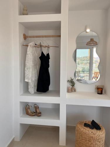 a dressing room with a shelf with a black dress and a mirror at Villa Livia- panoramic view with pool and beautiful garden in Pitsidia