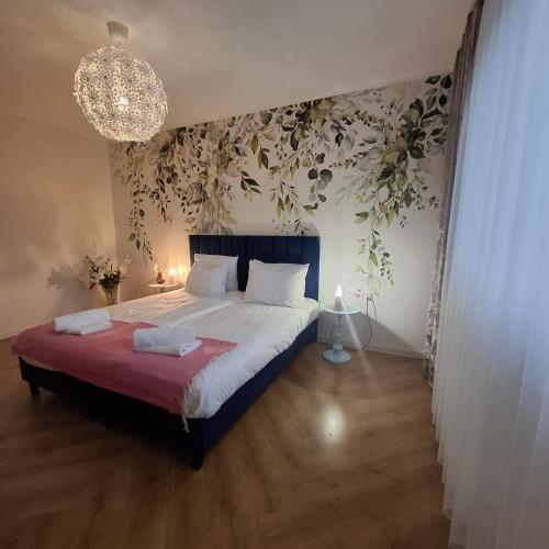 a bedroom with a bed with a plant wall at Apartamenty TUTERRA I in Zabagnie