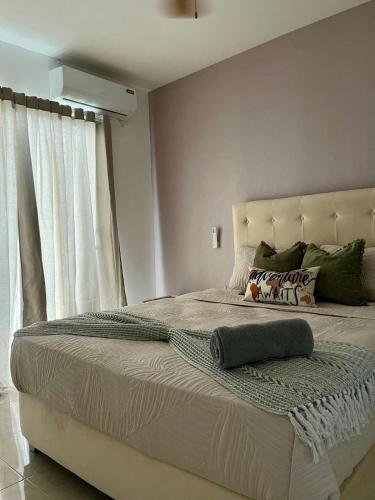 a bedroom with a large bed with a pillow on it at Modern 3BR Apmt Near Airport & Beach in San Isidro