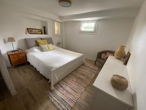 a bedroom with a white bed and a table at Between city and countryside in Maisons-Laffitte