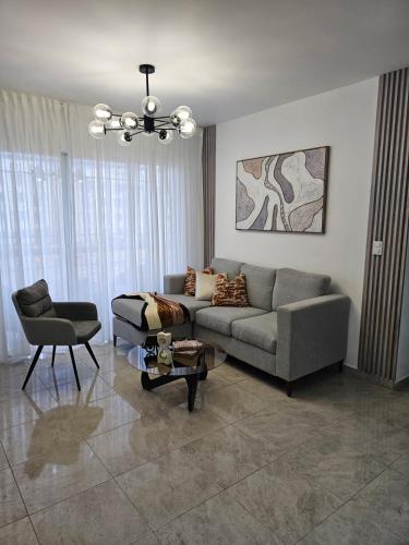 a living room with a couch and a chair at Modern 3BR Apmt Near Airport & Beach in San Isidro