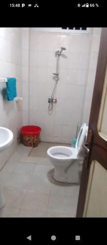 a white bathroom with a toilet and a sink at Appartement meublés de luxe in Dakar