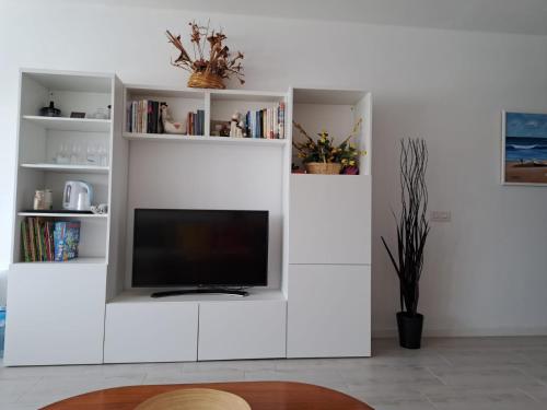 a white entertainment center with a flat screen tv at Tabaiba Place in Tías