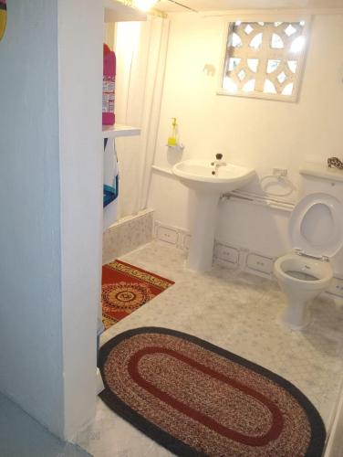a bathroom with a toilet and a sink at Casa Del Artista in Ukunda