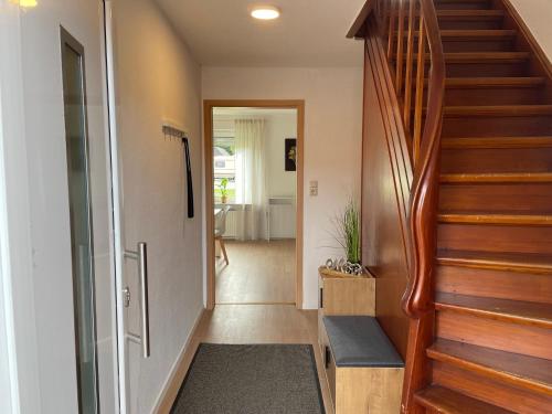 a hallway with a wooden staircase with a stair bench at Ferienhaus Söten Wind in Upgant-Schott