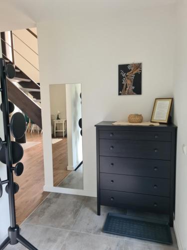 a bedroom with a black dresser and a staircase at Kambarių nuoma Naujojoje Akmenėje in Naujoji Akmenė