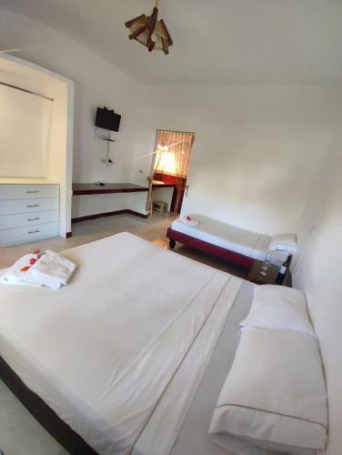 a bedroom with a large bed and a couch at Kanus Ayangue in Ayangue