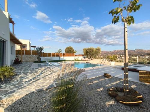 a swimming pool with a palm tree in a yard at Villa Livia- panoramic view with pool and beautiful garden in Pitsidia