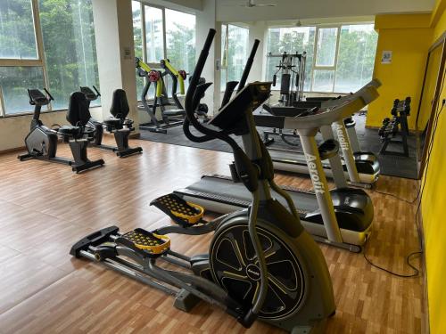 a gym with several treadmills and a treadmill at Luxury AC 2BHK Full Furnished with Sunrise View, Hill View, Pool, Kitchen, Ergonomic Workstation in Hinjewadi