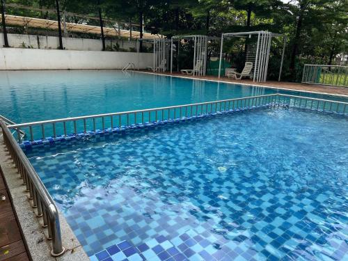 a large swimming pool with blue tiles on it at Luxury AC 2BHK Full Furnished with Sunrise View, Hill View, Pool, Kitchen, Ergonomic Workstation in Hinjewadi