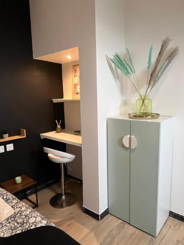 une chambre avec un lit et un bureau avec un vase dans l'établissement charmant duplex 2, au Havre