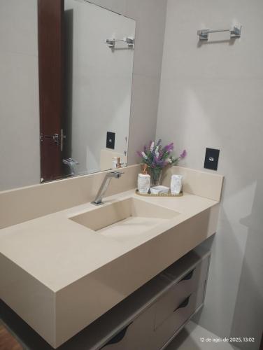 a bathroom with a sink and a mirror at Quarto com ar e banheiro estacionamento e Wi-Fi in Sinop