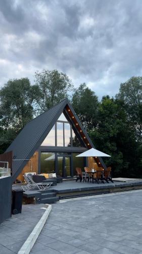 a house with a roof with chairs and an umbrella at AVA Chalet in Comarnic