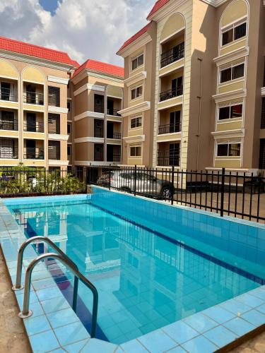 a swimming pool in front of a building at Lipsy Homes Kungu in Kampala
