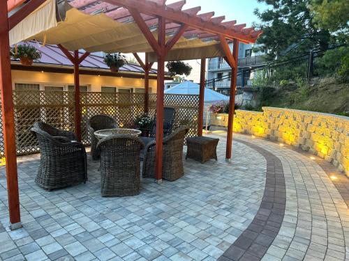 a patio with chairs and tables under a pavilion at Villa Adele in Polanica-Zdrój