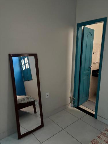 a mirror in a room with a chair and an open door at Alugo andar inteiro de casa para a COP30 in Ananindeua