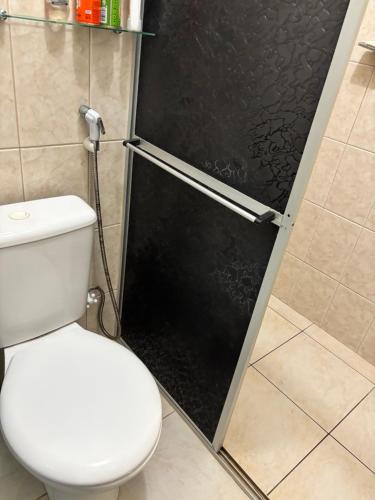 a bathroom with a toilet and a black door at Alugo andar inteiro de casa para a COP30 in Ananindeua