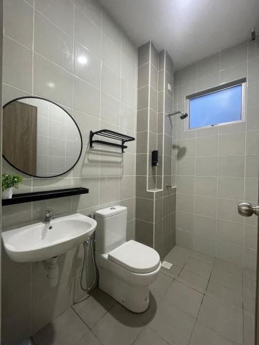 a bathroom with a toilet and a sink and a mirror at Simfoni Jitra Homestay in Jitra