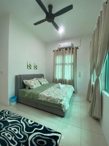 a bedroom with a bed and a ceiling fan at Simfoni Jitra Homestay in Jitra