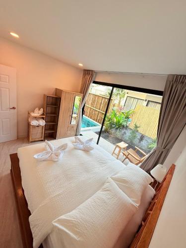 a bedroom with a large bed with a large window at Srithanu Escape 3 in Ban Madua Wan