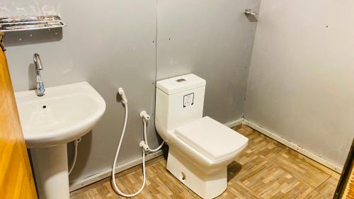 a bathroom with a toilet and a sink at Golden Beach Cottages in Trincomalee