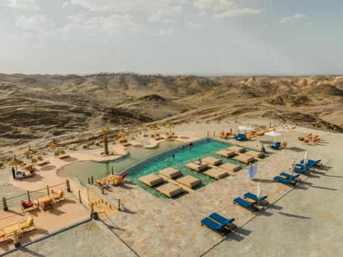 an aerial view of a swimming pool in the desert at The seven saints - luxury camp - lodges & tents - desert activities in El Karia
