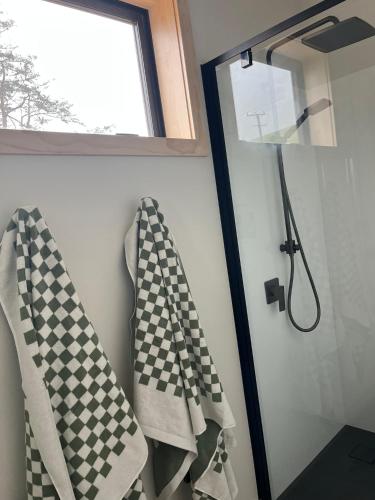 a bathroom with checkered towels and a window at Blimeys at Roselle in Portobello