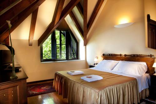 a bedroom with a large bed with two towels on it at Hotel Villa Giulia in Gargnano